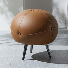 Buttoned faux leather footstool in modern round design, luxurious addition to any living space