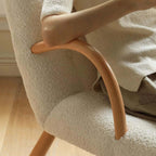 White and green lounge chair with boucle sherpa upholstery and solid wood armrests