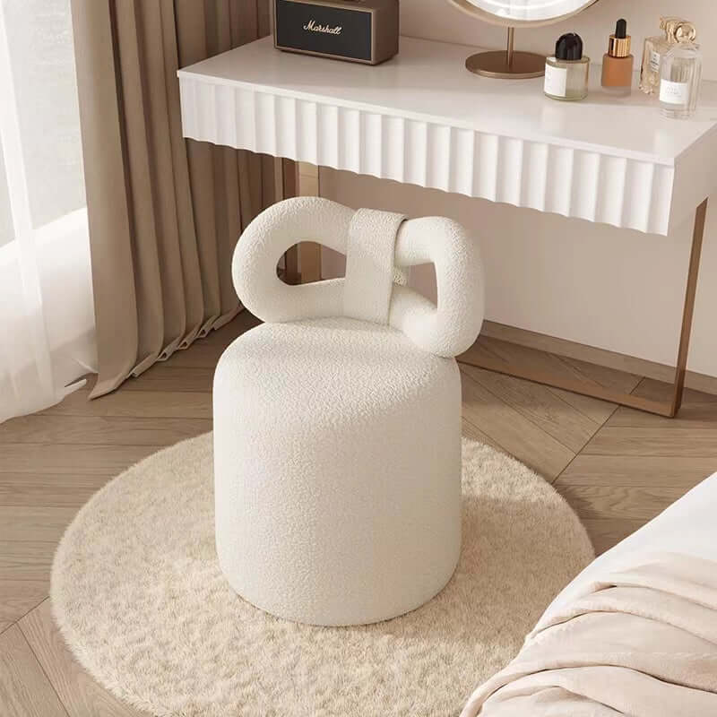 Butterfly-shaped vanity stool in cream-colored boucle fabric with soft texture