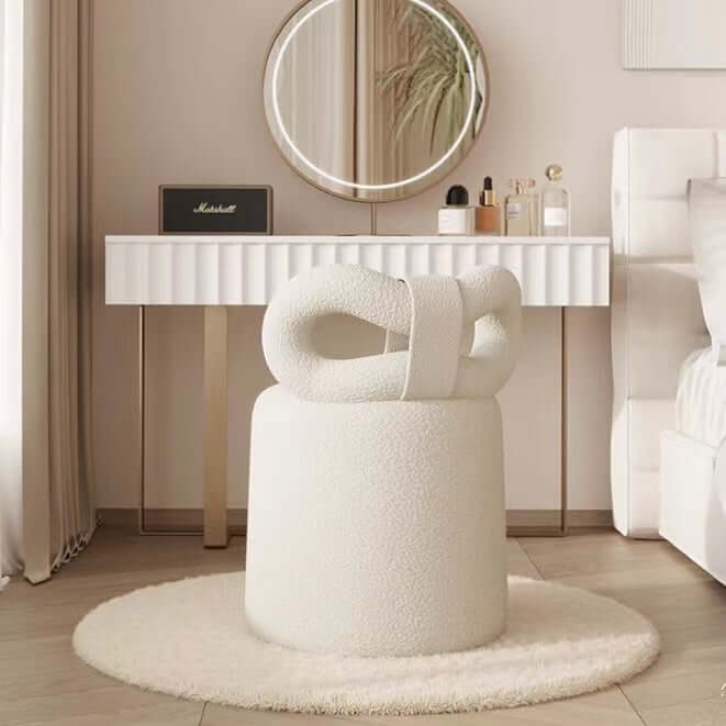 Butterfly-shaped vanity stool in cream-colored boucle fabric with soft texture