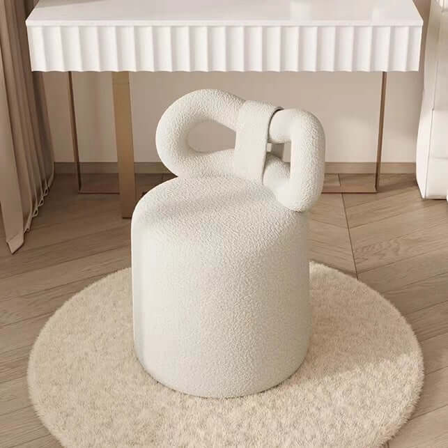 Butterfly-shaped vanity stool in cream-colored boucle fabric with soft texture