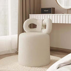 Butterfly-shaped vanity stool in cream-colored boucle fabric with soft texture