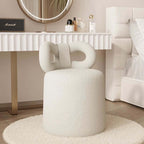 Butterfly-shaped vanity stool in cream-colored boucle fabric with soft texture