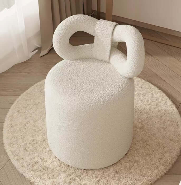 Butterfly-shaped vanity stool in cream-colored boucle fabric with soft texture
