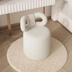 Butterfly-shaped vanity stool in cream-colored boucle fabric with soft texture