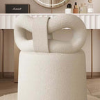 Butterfly-shaped vanity stool in cream-colored boucle fabric with soft texture