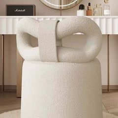 Cream-colored butterfly-shaped vanity stool with boucle texture