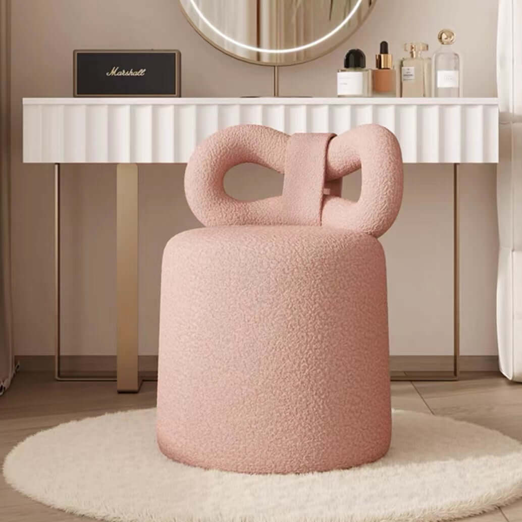 Butterfly-shaped vanity stool in cream-colored boucle fabric with soft texture