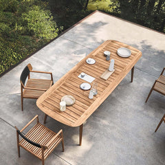 Modern outdoor dining set with teak wood table and chair in natural surroundings