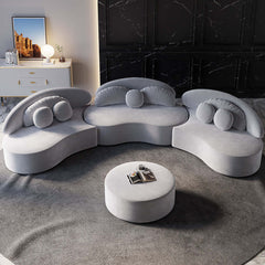 Round sectional beige sofa upholstered in luxurious velvet with ottoman and throw pillows