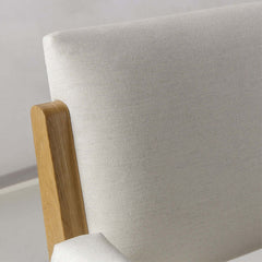 Modern beige arm chair with cotton and linen upholstery, supported by sturdy black carbon steel